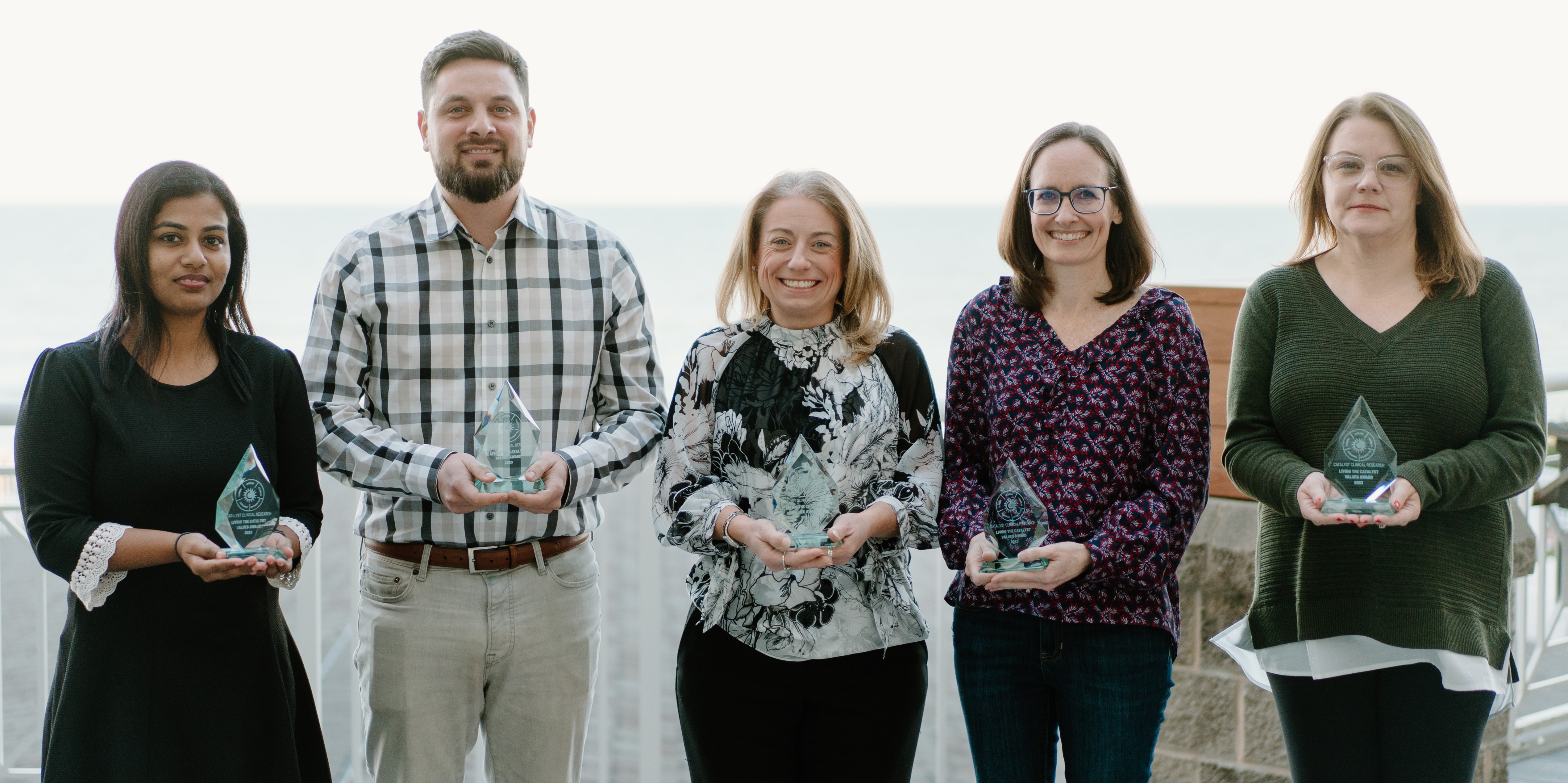 Five Catalyst employees holding awards.