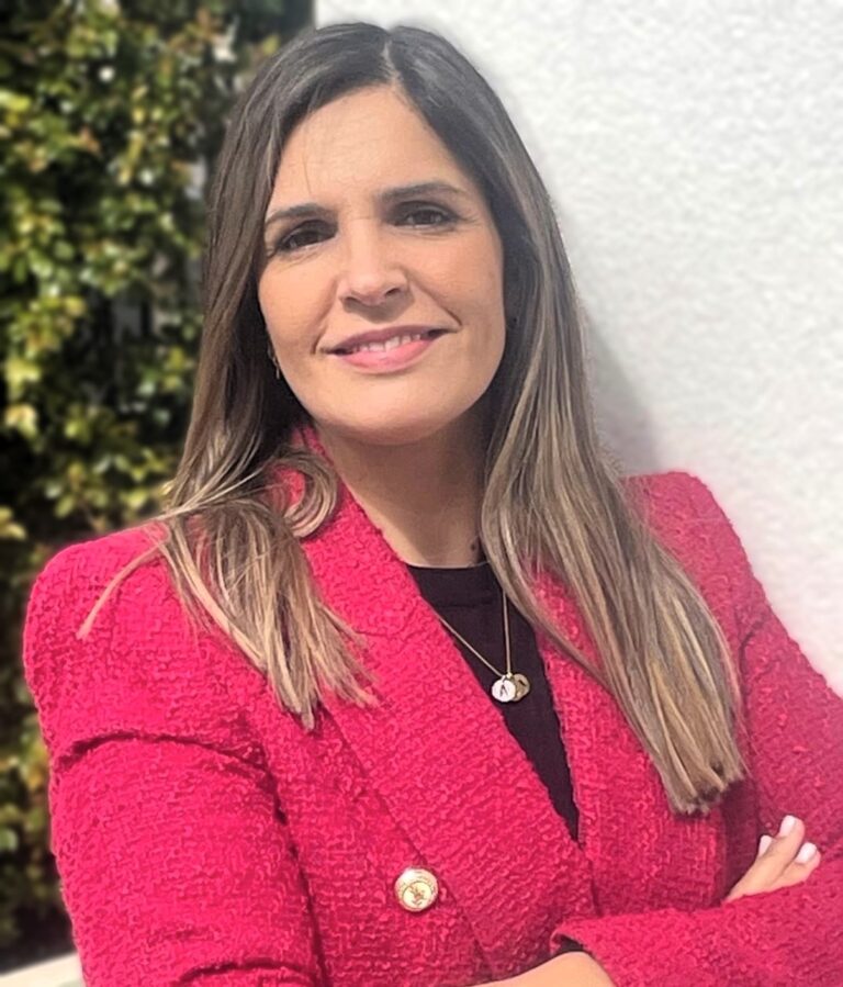 Inês Vale De Gato headshot with pink blazer and arms crossed