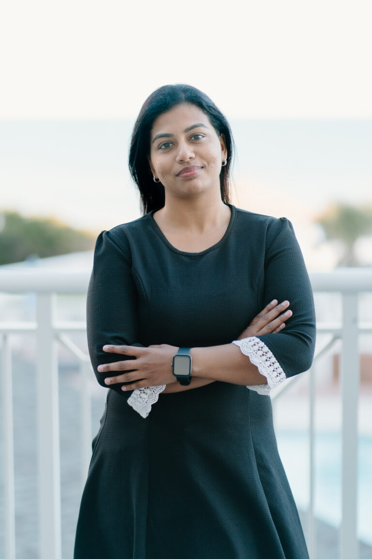 Medium range photo of Limna Salim in a dress and arms crossed.