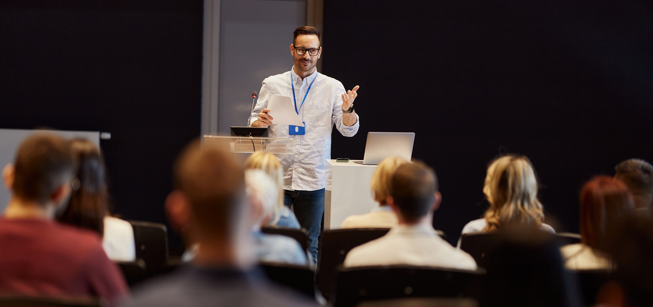 Person addressing conference and presenting a poster.